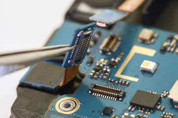 Disassembly of smartphone showing electrical board inside. The phone is fixing