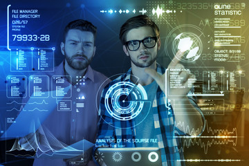 Global security. Professional team of programmers touching futuristic screen while using a new...