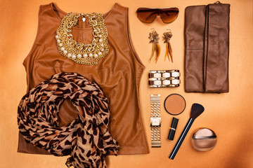Trendy woman accessories. Brown, beige and ocher modern outfit. Jewelry, make up, and clothes. Top...