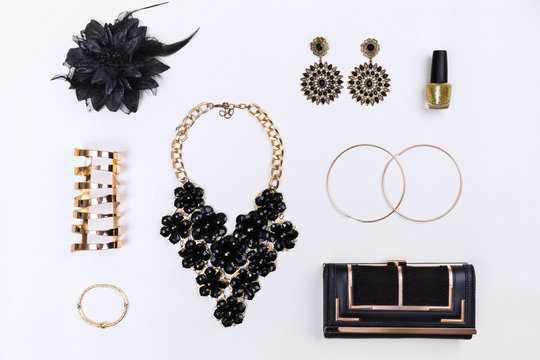 Trendy woman accessories. Black and gold modern jewelry. Top view.