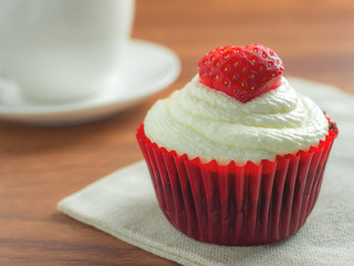 Close-up image of red velvet strawberry cup cake on coffee cup background with copy space, Valentine concept