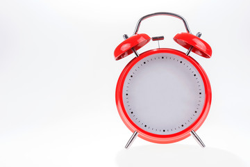 Old red retro alarm clock without numbers isolated on white background