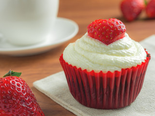 Close-up image of red velvet strawberry cup cake on coffee cup background with copy space, Valentine concept