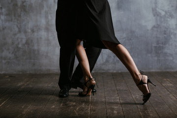 Young pretty woman in black dress and man dance tango - obrazy, fototapety, plakaty