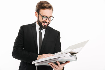Cheerful young businessman reading documents in folders.