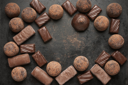 Assorted chocolate candies on dark background