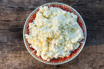Homemade cottage cheese on old wooden table