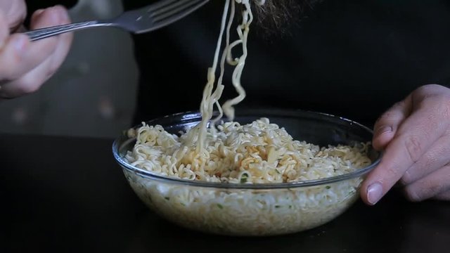 bearded man eating instant noodles