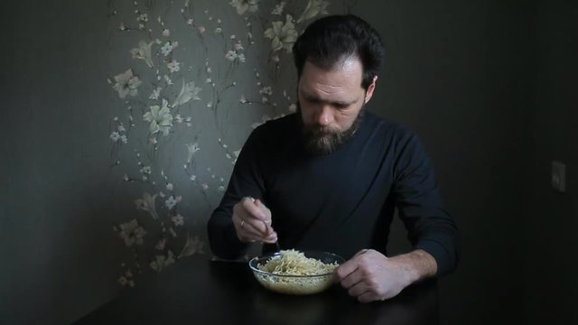 bearded man eating instant noodles