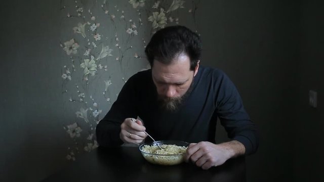 bearded man eating instant noodles