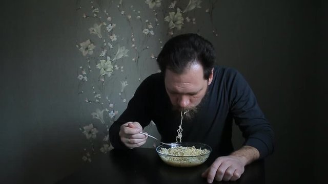 bearded man eating instant noodles