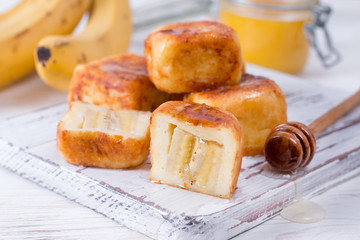 Cottage cheese pancakes in the form of cubes with honey on a white background
