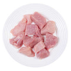 Raw pork meat pieces on a white plate