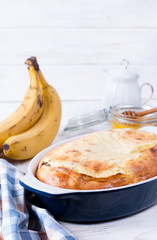 Cottage cheese casserole in ceramic form on a white wooden background