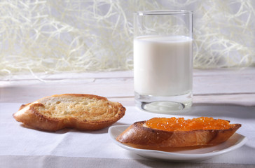 Morning Breakfast set with orange jam on bread toast and milk in glass.