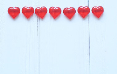 red hearts on white wooden background. photo with copy space.