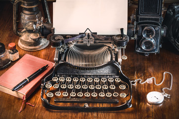Traditional and old way of writing messages and taking photos, typewriter, camera, watch, pen, Vintage lamp on the desk