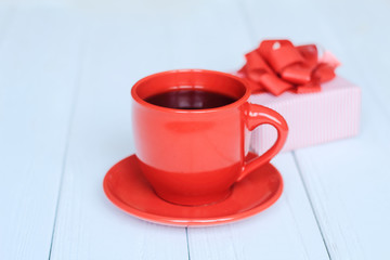 gift box and red Cup on a light wooden background