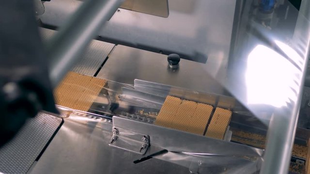 Sweet pastries packing line. Fresh wafers are packed into cellophane packaging.