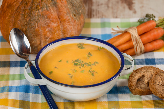 Rural pumpkin soup on rustic table