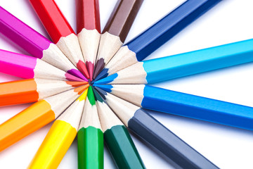 a circle of sharpened colored pencils on a white background.