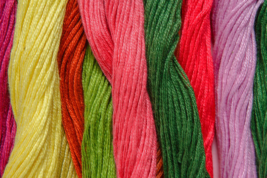 Set of multicolored threads for embroidery on  background close-up with copy space