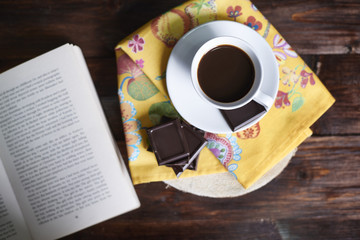 Coffee and book on wooden table .