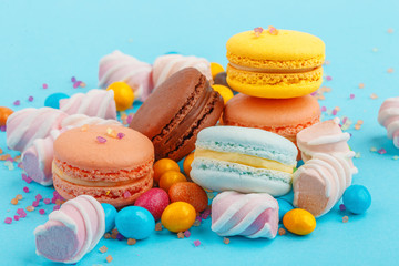 Macarons and sweets on a colored background. Festive mood