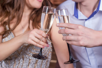 Celebrating Christmas and New Year. Couple holding glasses with champagne