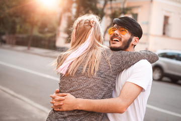 Young man and female are whirling on the street at the evening.