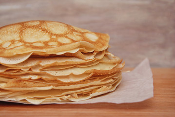 Stack of Tinny Pancakes on Kitchen Table with copy Space. Pancake's Day. Breakfast or Food Dessert.