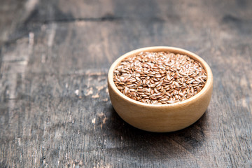 close up of flax seeds on dark wooden background. Healthy food concept for preventing heart diseases and overweight.
