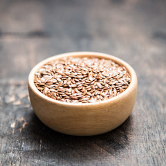 close up of flax seeds on dark wooden background. Healthy food concept for preventing heart diseases and overweight.