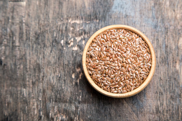 close up of flax seeds on dark wooden background. Healthy food concept for preventing heart diseases and overweight.