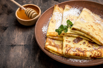 fresh pancakes with fragrant maple syrup and honey. Russian holiday pancake week. crepes with honey or syrup
