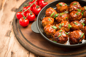Meatballs in sweet and sour tomato sauce. Homemade roasted beef meatballs in cast-iron skillet