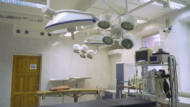 Operating room at hospital with equipment and medical devices. Table for surgical operations in the hospital. Interior of operating room in modern clinic.