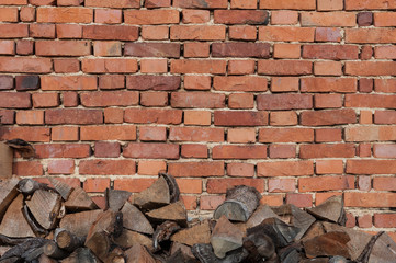 Background of old vintage brick wall with pile of firewood at the bottom
