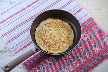 The Russian pancakes with a stuffing on a white plate on a light background. Maslenitsa.