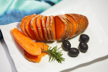 Homemade Orange Sweet Potato with olives and rosemary.  Hassel back potato.