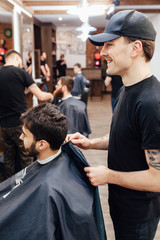 man getting trendy haircut at barber shop.
