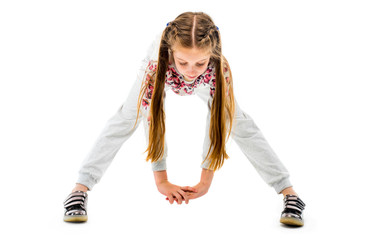 Little girl do forward bend exercise in grey sportwear, isolated on white background. Healthy lifestyle