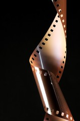 Obraz premium Roll of rolled-up photographic film on a black background.