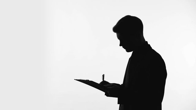 Man silhouette writing answers into questionnaire sheet, statistical surveys