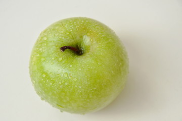green apple with water drop on tile background