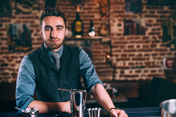 Barman working at bar, pub or bistro and restaurant. Professional elegant bartender making drinks