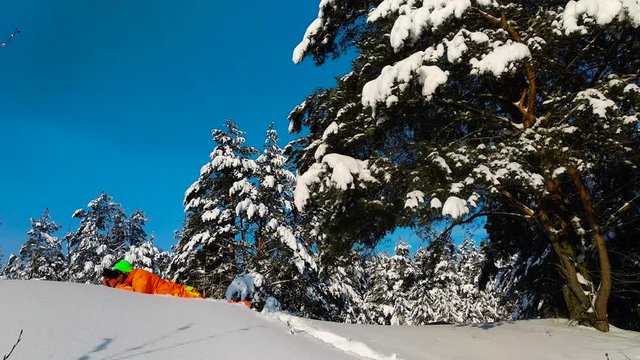 Photographer with camera laying on a snow and taking photo