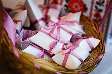 Gift boxes with pink bows lie in a wicker basket.