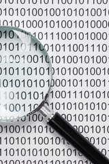 magnifying glass on a binary code