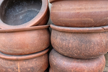 Fototapeta premium Handmade big clay casseroles stacked in front of the wall